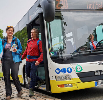 Eine Gruppe Wanderer steigt aus einem Bus